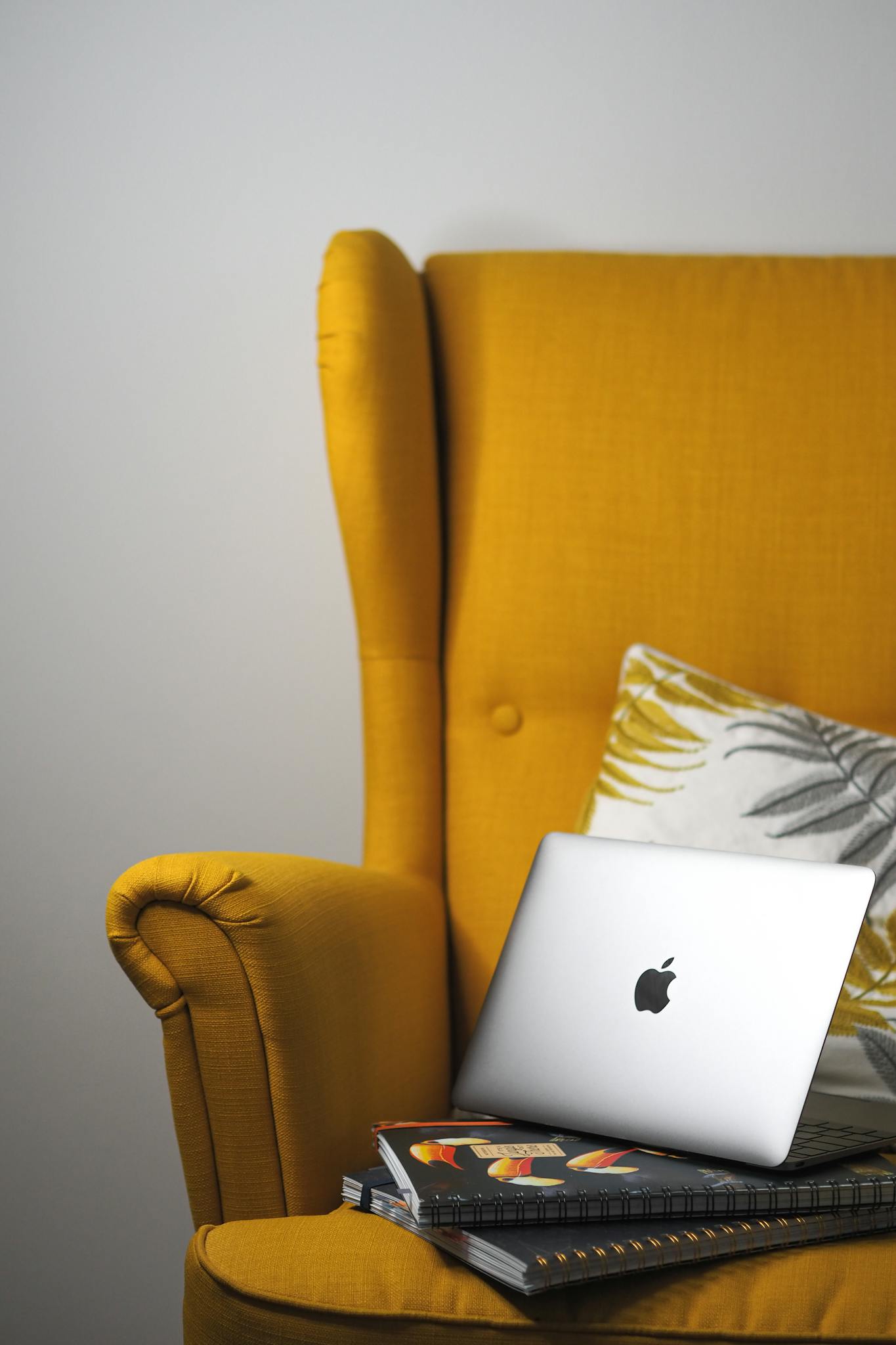 Stylish setup with a MacBook on a yellow armchair, Parisian inspired.